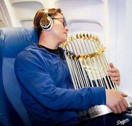 山本由伸さん、優勝トロフィーを抱いて機内でグッスリ眠る